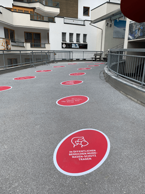 Coronaregels in Oostenrijk. Stickers bij de ingang van de Silvrettabahn wijzen bezoekers op de mondkapjesplicht in de gondels. © TVB Paznaun - Ischgl