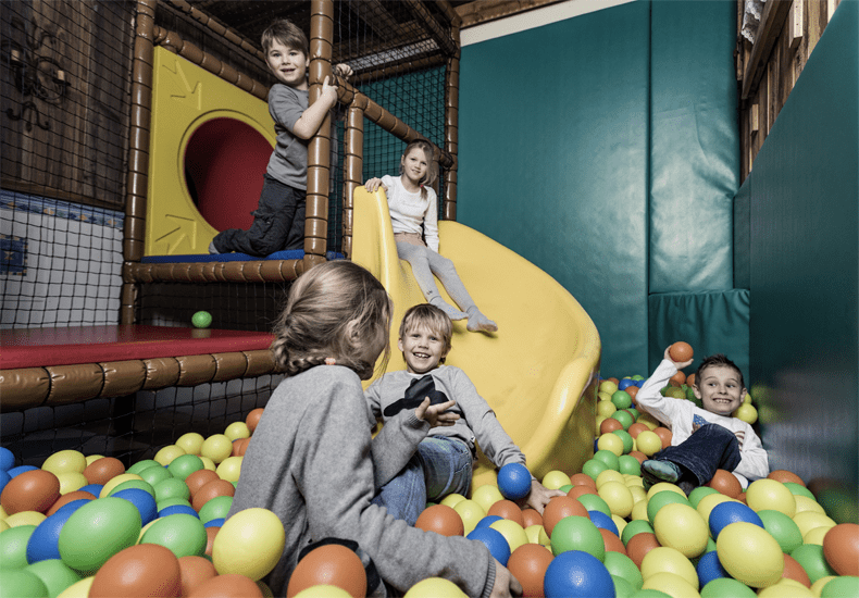 Ebner's Waldhof am See heeft aparte speelruimtes voor kinderen met onder meer een klimwand, tafelvoetbalspel en een ballenbad. © Ebner's Waldhof am See