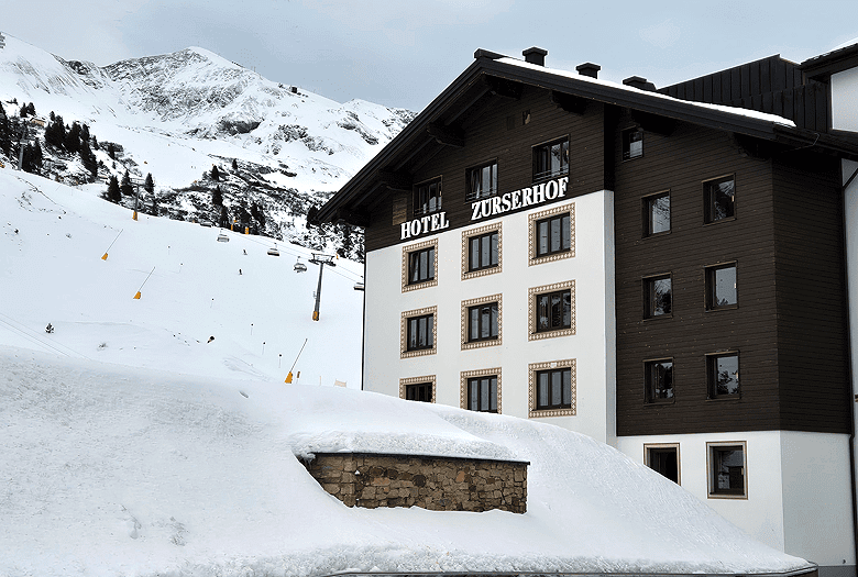 Grand Resort Hotel Zürserhof: superieure klasse, privacy en wellness aan de pistes van Zürs | WintersportOostenrijkGids.nl Hotel Zürserhof is een ski in ski out hotel in Zürs. Direct achter het hotel ligt het dalstation van de Seekopfbahn. Tegenover het hotel kun je in de gondels van de Hexenbahn stappen. © WintersportOostenrijkGids.nl