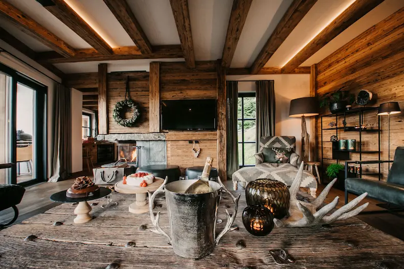 Het oude hout geeft de centrale woonkamer van de Lodge of Joy een warm karakter. © Selina Flasch Photography / Lodge of Joy