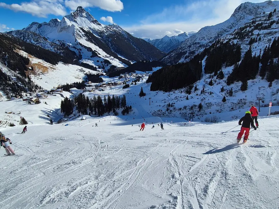 Rode piste 275 op de Steffisalpe gaat over in de rode 267 en is daarmee een van de langste rode pistes bij Warth. © WintersportOostenrijkGids.nl