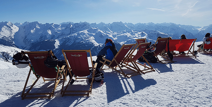 Bij pisterestaurant Arena Stadl in skigebied Zell am Ziller kun je heerlijk genieten van de zon en het uitzicht op de Zillertaler Alpen © WintersportOostenrijkGids.nl
