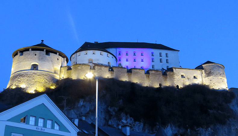 De vesting Kufstein, hier verlicht in de kleuren van de Oekraïnse vlag, domineert de omgeving van Kufstein en is eeuwenlang twistappel geweest tussen Tiroler en Beierse heersers © Wintersporoostenrijkgids.nl