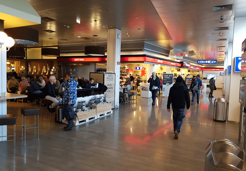 Op het vliegveld van Salzburg zijn achter de veiligheidscontrole niet heel veel faciliteiten zoals horeca en winkels. Links het Marktcafé en daarnaast de tax-free-shop © Wintersportoostenrijkgids.nl