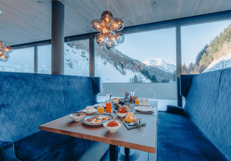 Al bij je ontbijt kun je in het ZillergrundRock Luxury Mountain Resort genieten van het uitzicht op de besneeuwde bergen. © Carmen Huter / ZillergrundRock