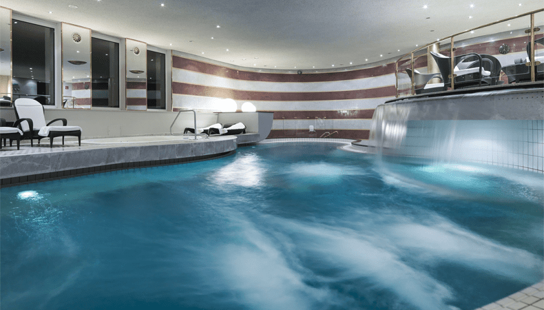 De Aureus Spa beschikt ook over een groot binnenzwembad met waterval © Rainer Hofmann Photodesign / Hotel Zürserhof
